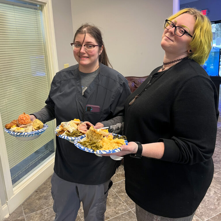 R-Dent employees smiling at the camera as they hold plates of food in their hands